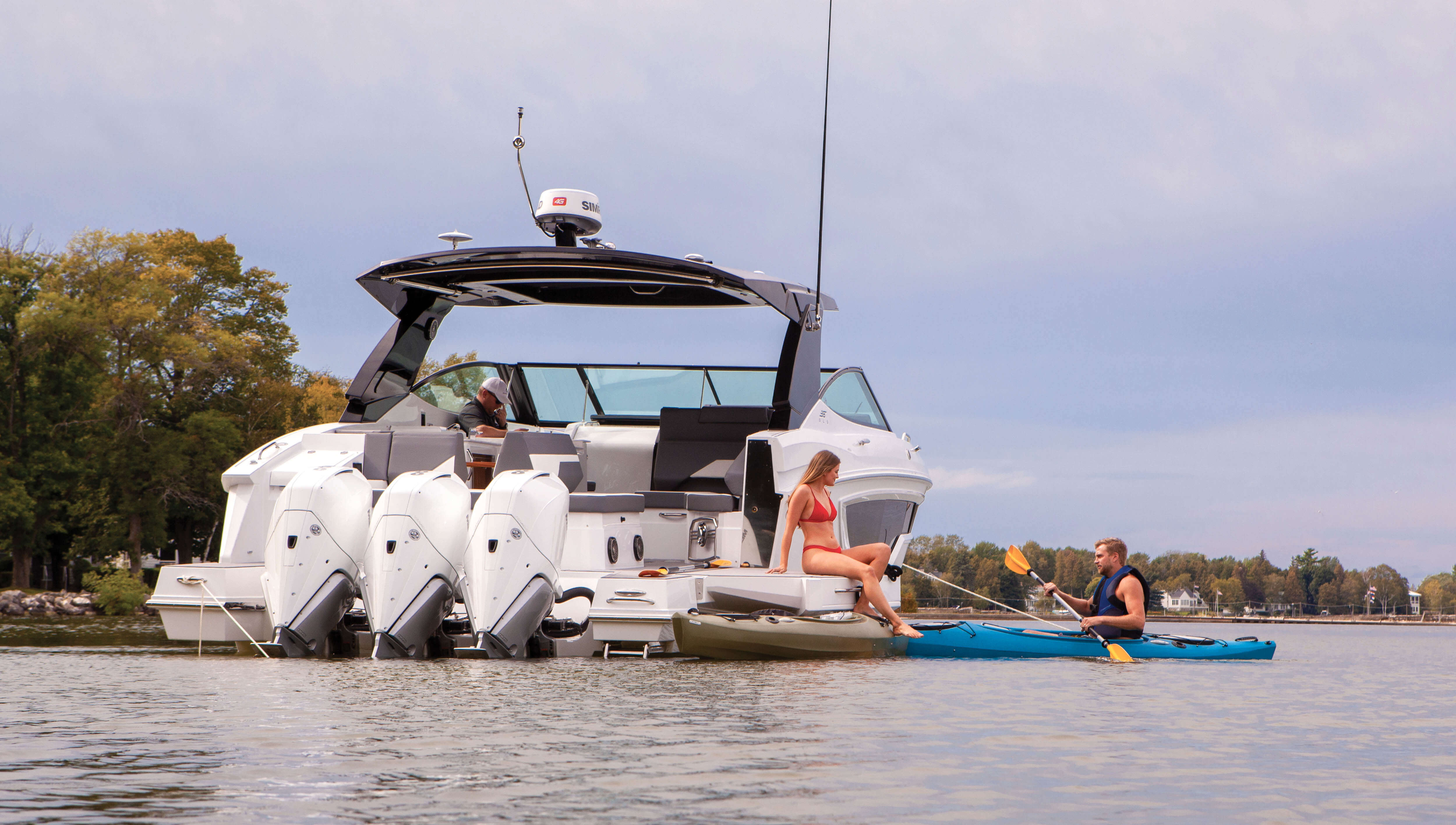 38 GLS OB in the water with people on kayak and lowered beach doors