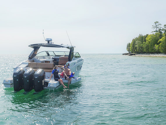 Couple sitting on the beach door on a Cruisers Yachts 38 GLS OB